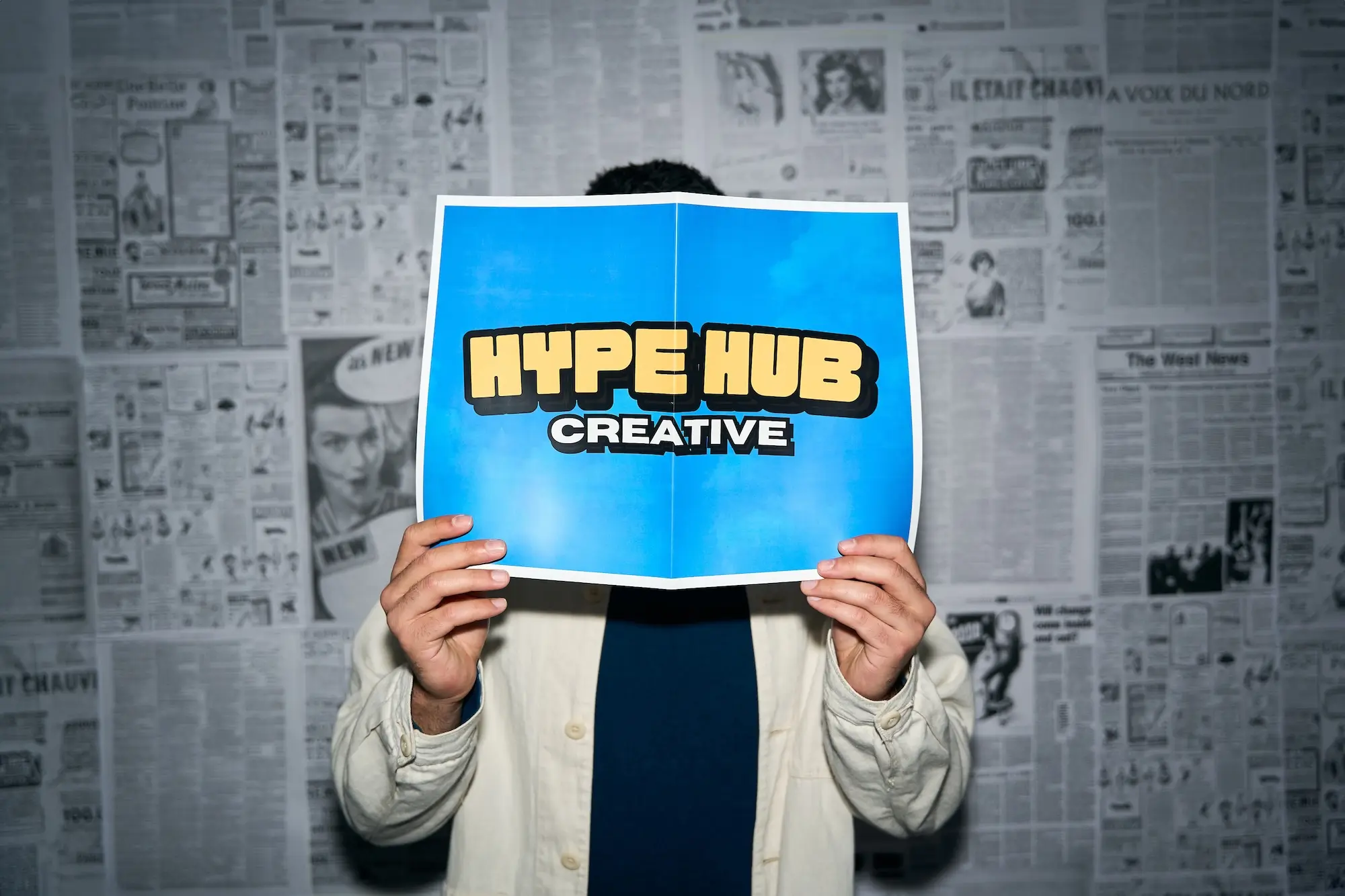 Thomas advertising Hype Hub Creative by holding poster with logo